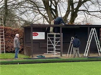 Members work on shelter roof